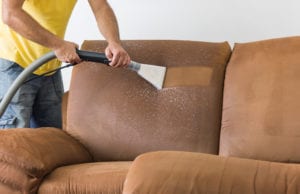 An image of a man cleaning upholstery. Once water damage is fixed, we get to work restoring your property.