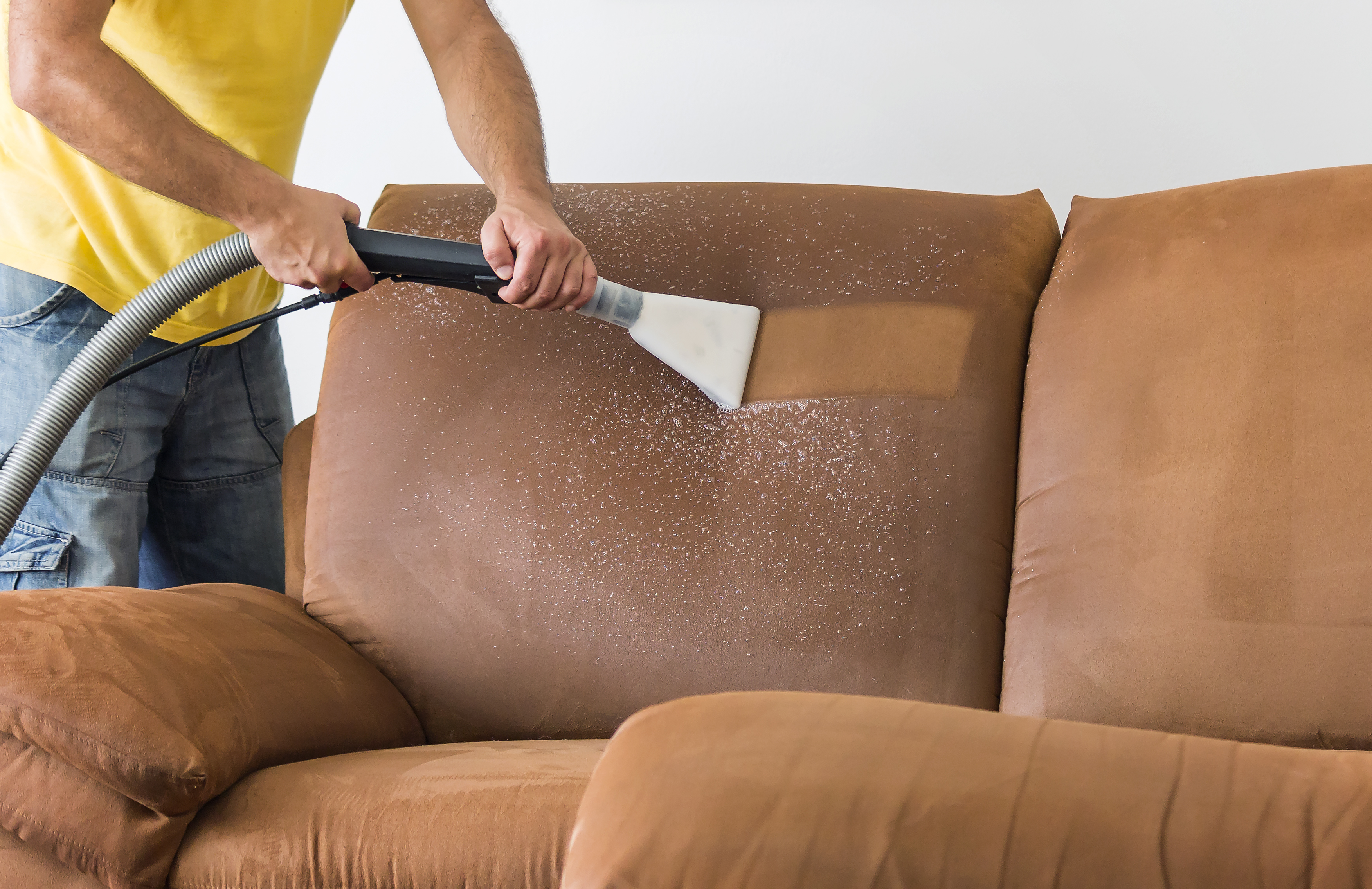 An image of a man cleaning upholstery. Once water damage is fixed, we get to work restoring your property.