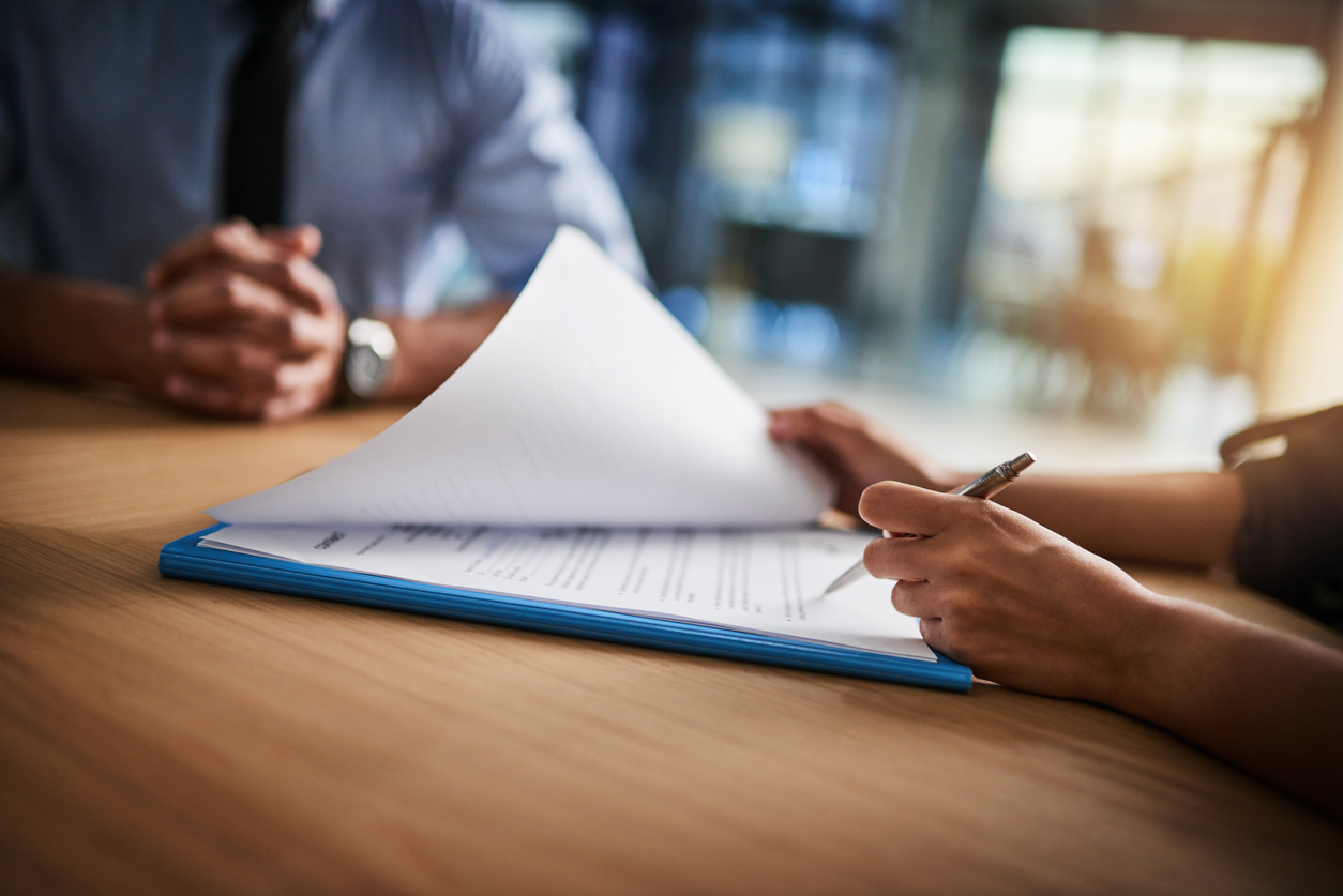 Combing through the fine print Cropped shot of a man and woman completing paperwork together at a desk